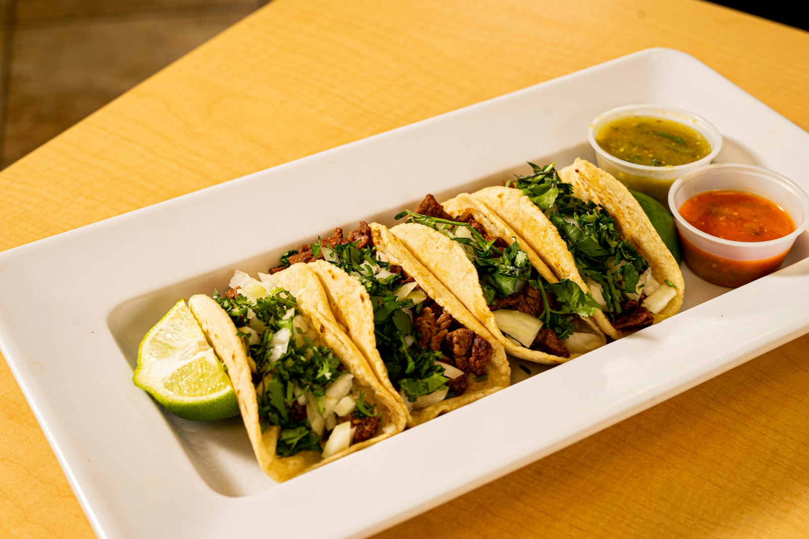 Plato de tacos callejeros con dos salsas, imagen representativa
